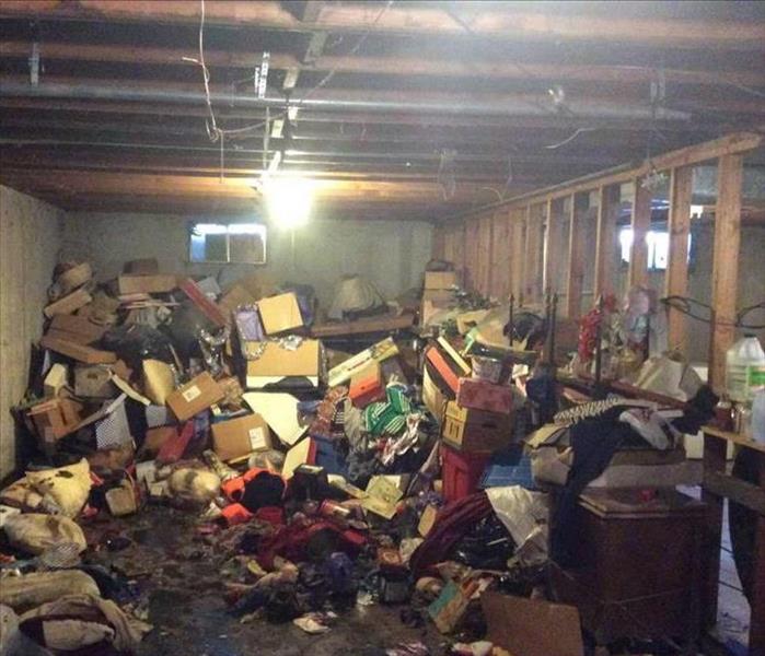 Cluttered basement has a water damage.