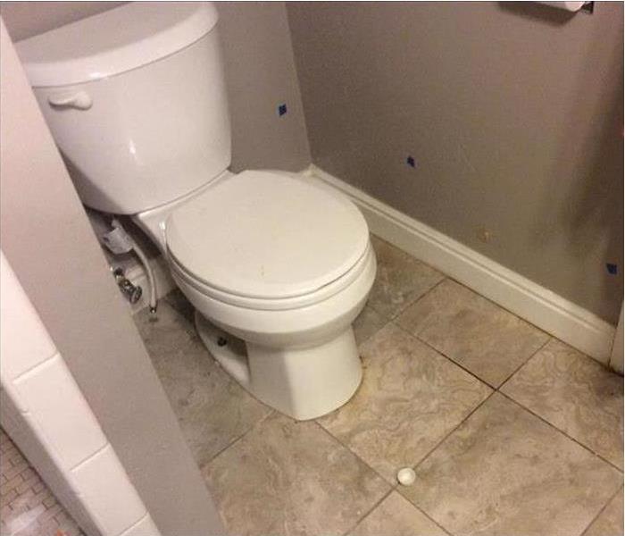 White toilet leaking water in bathroom