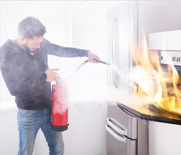 Man extinguishing fire in his kitchen.