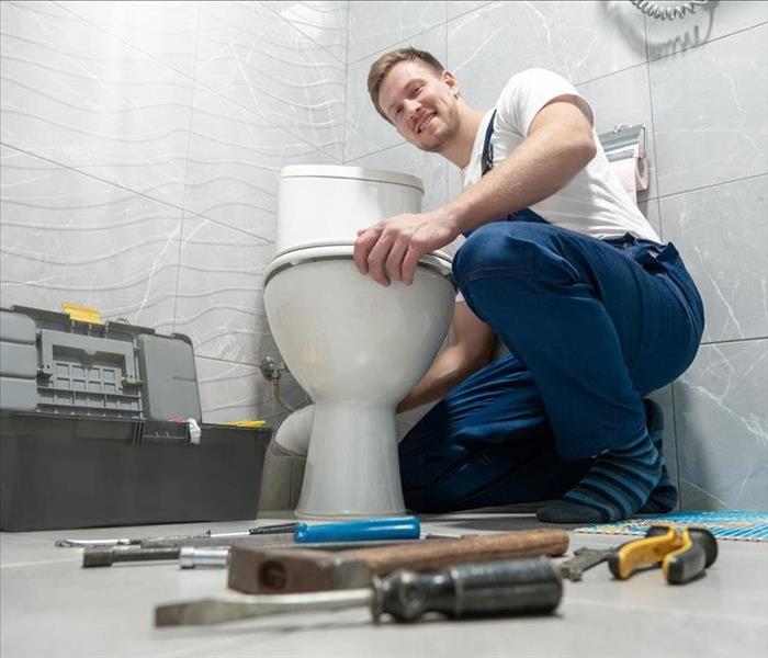 Image of a person replacing a toilet