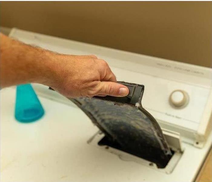 Image of a person removing the lint from a dryer