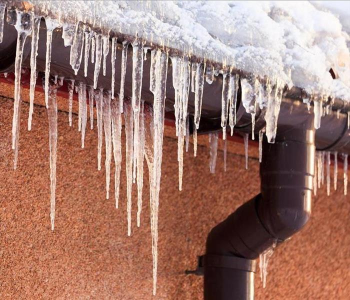 Image of icicles hanging off from the side of the roof of a home.